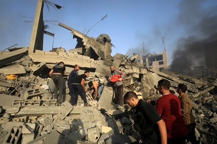 Palestinians search for casualties at the site of an Israeli strike on a residential building in Gaza City on October 25. (Reuters)