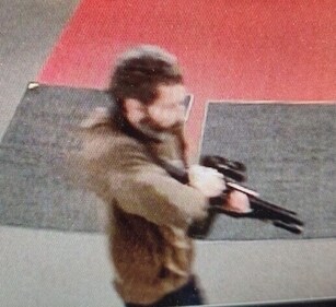 A man identified as a suspect by police points what appears to be a semiautomatic rifle, in Lewiston, Maine, US, on October 25. (Reuters)