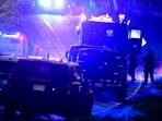 Law enforcement officers, right, stand near armored and tactical vehicles, center, near a property on Meadow Road, in Bowdoin, Maine, (AP)