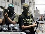 Palestinian militants from Hamas ride on a truck with their weapons