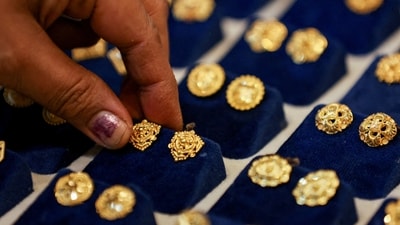 FILE PHOTO: FILE PHOTO: A woman picks a gold earring at a jewellery shop in the old quarters of Delhi, India, May 24, 2023. REUTERS/Anushree Fadnavis/File Photo/File Photo