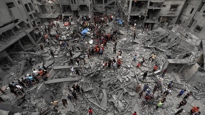 Palestinians inspect the damage of destroyed buildings following Israeli airstrikes on Gaza City. (AP Photo)