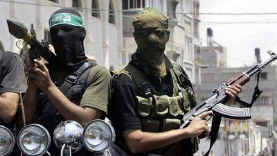 Palestinian militants from Hamas ride on a truck with their weapons (AP File) Palestinian militants from Hamas ride on a truck with their weapons (AP File)