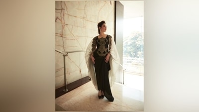 The Anamika Khanna outfit features a cropped blouse, skirt and a cape jacket embroidered with floral applique work in green and beige hues. While the top has embroidery on the front, the shrug has it on the borders. Lastly, the skirt and blouse come in a black shade, and the jacket in a mint green tint.&nbsp; (Instagram)