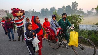 Villagers shift to a safer place following unprovoked firing by the Pakistan Rangers along the border in Arnia sector of Jammu district on Friday. (PTI Photo)