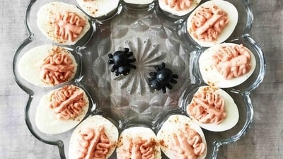Deviled Egg Brains: To craft Deviled Egg Brains, blend the egg yolks with a sinister red filling and then use piping to fill the egg white halves, creating an eerie Halloween snack.&nbsp; (Pinterest)