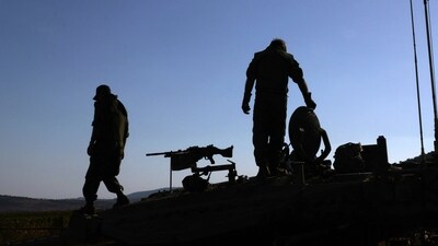 Israeli soldiers stand atop a Merkava tank during in a military drill near the border with Lebanon on October 26. (AFP)