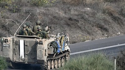 Israel-Hamas War: Israeli soldiers ride an armoured vehicle along a road on the outskirts of the southern Israeli city of Sderot. (AFP)