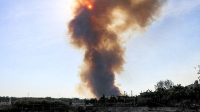 TOPSHOT - A smoke plume covers the sun during a forest fire that reportedly ignited after shell fire from Israel, in the Labouneh area in southern Lebanon close to the border with northern Israel, on October 26, 2023, amid the ongoing battles between Israel and the Palestinian group Hamas in the Gaza Strip. (Photo by AFP) (AFP) TOPSHOT - A smoke plume covers the sun during a forest fire that reportedly ignited after shell fire from Israel, in the Labouneh area in southern Lebanon close to the border with northern Israel, on October 26, 2023, amid the ongoing battles between Israel and the Palestinian group Hamas in the Gaza Strip. (Photo by AFP) (AFP)