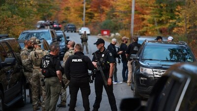 BOWDOIN, MAINE - OCTOBER 26: Law enforcement officials gather in the road leading to the home of the suspect being sought in connection with two mass shootings on October 26, 2023 in Bowdoin, Maine. Police are searching for U.S. Army Reservist Robert Card, 40, who is wanted in the shooting deaths of 18 people at a bowling alley and a bar last night in nearby Lewiston. At least 13 others were wounded in the rampage. Joe Raedle/Getty Images/AFP (Photo by JOE RAEDLE / GETTY IMAGES NORTH AMERICA / Getty Images via AFP) (Getty Images via AFP) BOWDOIN, MAINE - OCTOBER 26: Law enforcement officials gather in the road leading to the home of the suspect being sought in connection with two mass shootings on October 26, 2023 in Bowdoin, Maine. Police are searching for U.S. Army Reservist Robert Card, 40, who is wanted in the shooting deaths of 18 people at a bowling alley and a bar last night in nearby Lewiston. At least 13 others were wounded in the rampage. Joe Raedle/Getty Images/AFP (Photo by JOE RAEDLE / GETTY IMAGES NORTH AMERICA / Getty Images via AFP) (Getty Images via AFP)