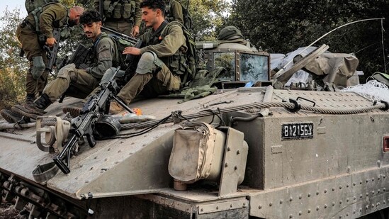 Israel-Hamas War: Israeli army soldiers sit atop a tracked vehicle at a position in the upper Galilee region of northern Israel. (AFP)