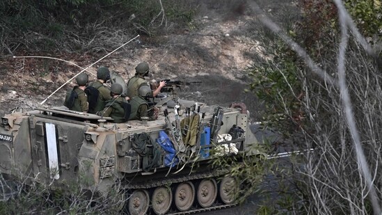 Israel-Hamas War: Israeli soldiers ride an armoured vehicle along a road on the outskirts of the southern Israeli city of Sderot. (AFP)