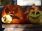 A shaft of light hits pumpkins carved to mark Halloween outside a home on Clarkson Street on Friday, Oct. 27, 2023, in Denver.