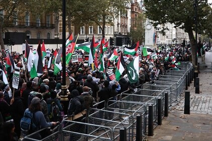 Protesters hold up placards and wave Palestinian flags at the gates of Downing Street in London on October 28. (AFP) Protesters hold up placards and wave Palestinian flags at the gates of Downing Street in London on October 28. (AFP)
