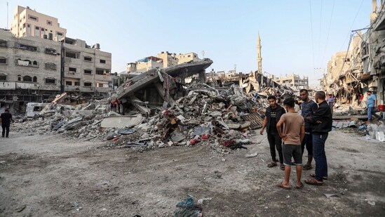 Palestinians inspect the damage of destroyed buildings caused by the ongoing Israeli airstrikes on Gaza City on October 28. (AP)