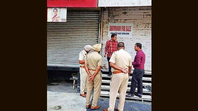 Officials sealing a showroom constructed in violation of building bylaws in Ludhiana . (ht photo)