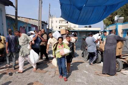 Palestinians storm a UN-run aid supply center, that distributes food to displaced families following Israel's call for more than one million residents in northern Gaza to move south for their safety, in Deir al-Balah on October 28. (AFP)