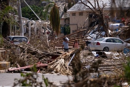 People walk next to rubble and damaged trees in the aftermath of Hurricane Otis, in Acapulco, Mexico, October 29, 2023. (Reuters)