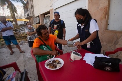 A man is being examined, as people line up for medicine and check-ups from a medical unit, in the aftermath of Hurricane Otis, near Caleta beach in Acapulco, Mexico. (Reuters)