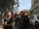 An injured Palestinian is assisted at the site of an Israeli strike on a house in Rafah in the southern Gaza Strip October 30