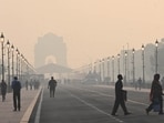 Commuters out on a smoggy morning amid rising air pollution at Kartavya Path in New Delhi on October 27.