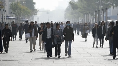 People walk along a business street in Beijing (AFP) People walk along a business street in Beijing (AFP)