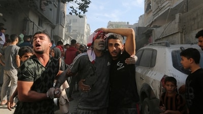 An injured Palestinian is assisted at the site of an Israeli strike on a house in Rafah in the southern Gaza Strip October 30 (REUTERS)