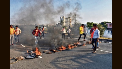 Members of Maratha Kranti Morcha burn tyres and other inflamable items on Pune-Solapur Highway, on Tuesday. (PTI) Members of Maratha Kranti Morcha burn tyres and other inflamable items on Pune-Solapur Highway, on Tuesday. (PTI)