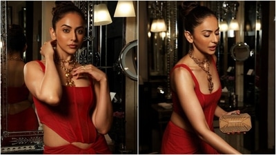 The corset blouse has a sleeveless design, a wide square neckline, structured boning, corseted bodice, an asymmetric cropped hem, and a bodycon fitting. Rakul teamed it with a matching fiery red-coloured skirt featuring an asymmetric high-rise waist, figure-skimming fit, gathered design on the front, and a floor-grazing hem length. (Instagram) The corset blouse has a sleeveless design, a wide square neckline, structured boning, corseted bodice, an asymmetric cropped hem, and a bodycon fitting. Rakul teamed it with a matching fiery red-coloured skirt featuring an asymmetric high-rise waist, figure-skimming fit, gathered design on the front, and a floor-grazing hem length. (Instagram)