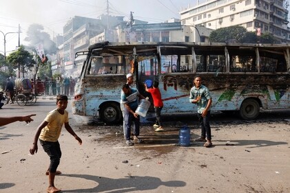 People try to douse the fire inside a public bus after it was set ablaze by unidentified people during a countrywide strike on October 29. (Reuters)