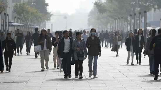 People walk along a business street in Beijing (AFP)