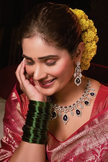 .Sahai contrasts her red Banarasi saree with a diamond and blue sapphire necklace by Naulakha Jewellers. Her red Banarasi saree by Asha Gautam, accented with gold border, features zari work throughout. She wears gorgeous fresh marigold flowers in her bun. .Sahai contrasts her red Banarasi saree with a diamond and blue sapphire necklace by Naulakha Jewellers. Her red Banarasi saree by Asha Gautam, accented with gold border, features zari work throughout. She wears gorgeous fresh marigold flowers in her bun.