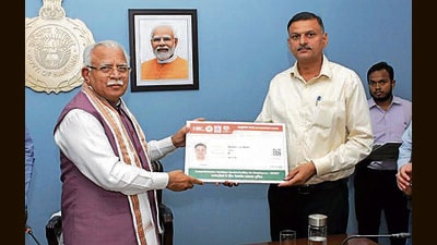 Haryana chief minister Manohar Lal Khattar hands over Ayushman Bharat card to a beneficiary in Chandigarh on Wednesday. (HT Photo)