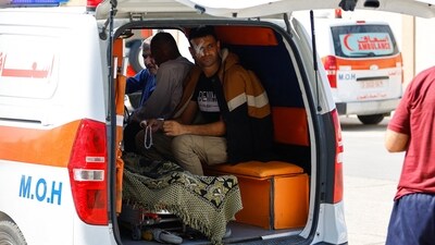 An injured Palestinian man sits in an ambulance, as he waits for medical workers to take him to receive treatment in an Egyptian hospital, at the Rafah border. (REUTERS)