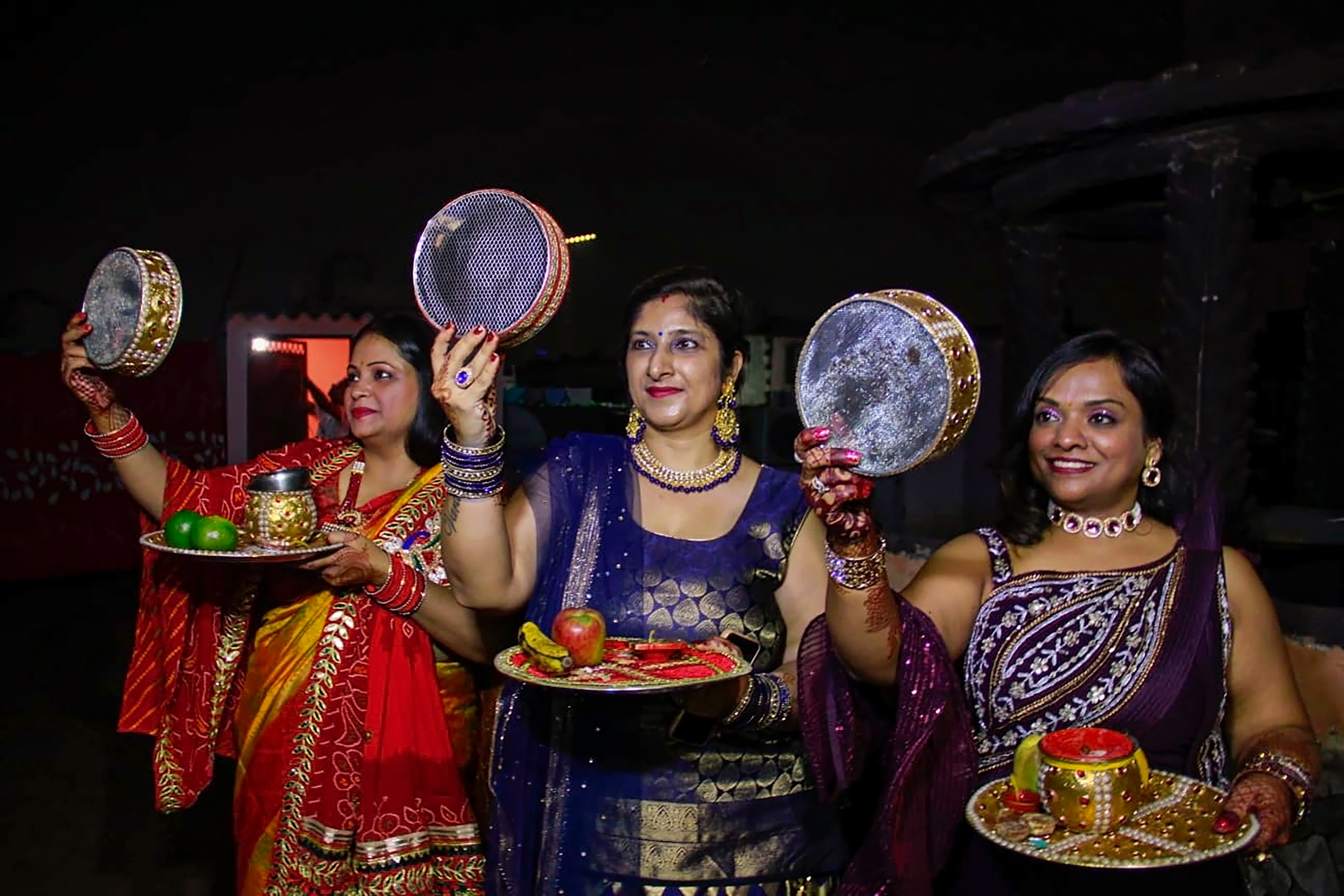 Married women look at the moon through a sieve during Karwa Chauth 2023. (PTI) Married women look at the moon through a sieve during Karwa Chauth 2023. (PTI)