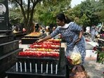 A Catholic Christian places roses over the grave of a family member at a cemetery during All Souls' Day in Hyderabad.(AFP)