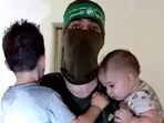 A Hamas terrorist with toddlers as hostages in Gaza. A Hamas terrorist with toddlers as hostages in Gaza.