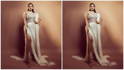 Her outfit is from the brand Yas Couture House of Fashion and features a criss-cross patterned top with silver embroidery and detailing. The bottom of her outfit features a thigh high side slit, fur trim at the hem and a dramatic back train. (Instagram/@shehnaazgill) Her outfit is from the brand Yas Couture House of Fashion and features a criss-cross patterned top with silver embroidery and detailing. The bottom of her outfit features a thigh high side slit, fur trim at the hem and a dramatic back train. (Instagram/@shehnaazgill)