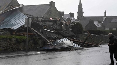 Pedestrians walk past a destroyed warehouse in Porspoder, western France. (AFP) Pedestrians walk past a destroyed warehouse in Porspoder, western France. (AFP)