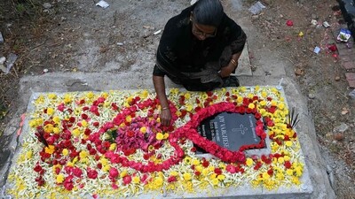 A Catholic Christian places flowers over the grave of a family member at a cemetery during All Souls Day in Hyderabad. (AFP)