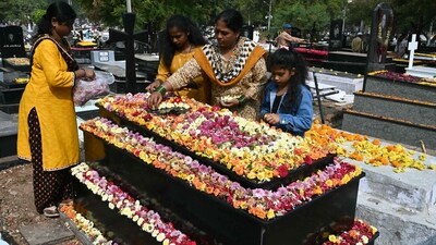 A Catholic family places flowers over the grave of their relative at a cemetery during All Souls Day in Hyderabad. (AFP)
