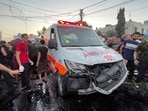 Palestinians check the damages after a convoy of ambulances was hit, at the entrance of Shifa hospital in Gaza City. (Reuters)
