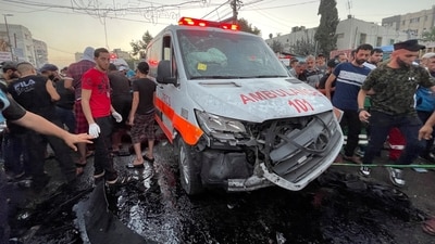 Palestinians check the damages after a convoy of ambulances was hit, at the entrance of Shifa hospital in Gaza City. (Reuters)