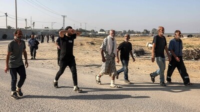 Palestinian workers, who were stranded in Israel since the October 7 attacks, cross back into the Gaza Strip at the Kerem Shalom commercial border crossing with Israel in the south of the Palestinian enclave on November 3, 2023. (AFP) Palestinian workers, who were stranded in Israel since the October 7 attacks, cross back into the Gaza Strip at the Kerem Shalom commercial border crossing with Israel in the south of the Palestinian enclave on November 3, 2023. (AFP)