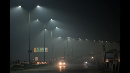 Cars ride along a highway engulfed by smog in Jalandhar. (AFP)