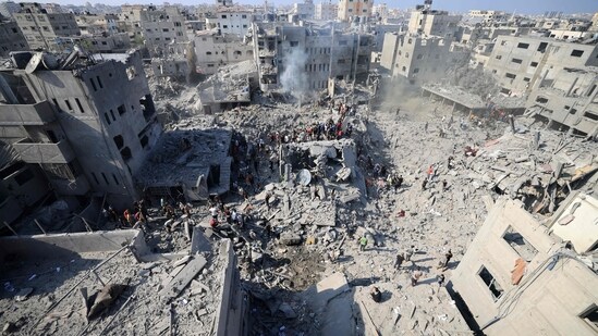 People check the rubble of buildings destroyed in an Israeli strike in central Gaza Strip