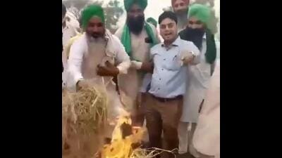 A video grab of farmers holding Punjab PWD sub divisional engineer Hardeep Sagar by the arm and forcing him to torch the paddy residue at Mehma Sarja village in Bathinda district on Friday. (X)