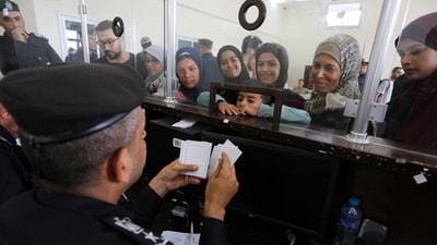 Palestinians with dual nationality register to cross into Egypt on the Gaza Strip side of the Rafah border crossing. (AP)
