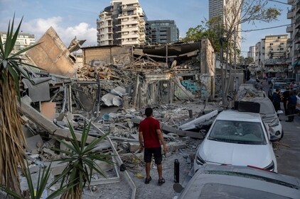 Israelis inspect the rubble of a building a day after it was hit by a rocket fired from the Gaza Strip, in Tel Aviv, Israel, Sunday, Oct. 8, 2023. (AP) Israelis inspect the rubble of a building a day after it was hit by a rocket fired from the Gaza Strip, in Tel Aviv, Israel, Sunday, Oct. 8, 2023. (AP)