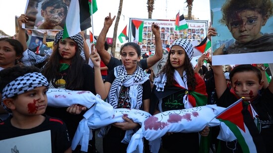 Palestinian children hold posters during a protest in solidarity with children in the Gaza Strip, in the city of Ramallah on November,4, 2023, amid the ongoing battles between Israel and the Palestinian group Hamas. (AFP)